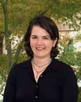 Portrait image of Elizabeth Freeman outdoors in front of trees wearing a black shirt