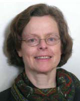 Portrait image of Julia Murray wearing thin glasses and a patterned scarf