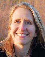 Portrait image of Julie K. Allen with long blonde hair outdoors with sunlight coming from the left side