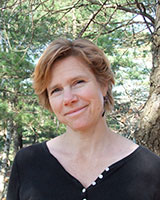 Portrait image of Nan Enstad outdoors in front of trees wearing a black shirt