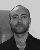 Black and White image of Jimmy Klausen wearing a dark button-up shirt