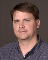 Portrait image of Matt Waters wearing a blue checkered shirt