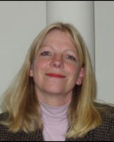 Portrait image of Louise Young wearing a pink turtle neck and checkered jacket