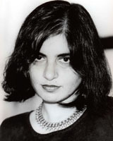 Black and white image of Preeti Chopra with shoulder-length dark hair, a dark shirt, and a large metal necklace