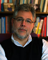 Portrait image of Russ Shafer-Landau in front of book shelves.