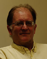 Portrait image of Craig Werner wearing a white/ivory/light yellow shirt and glasses