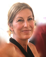 Portrait image of Kristin Phillips-Court wearing a black dress and gold earrings