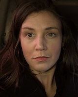 Closely-cropped portrait image of River Bullock wearing black