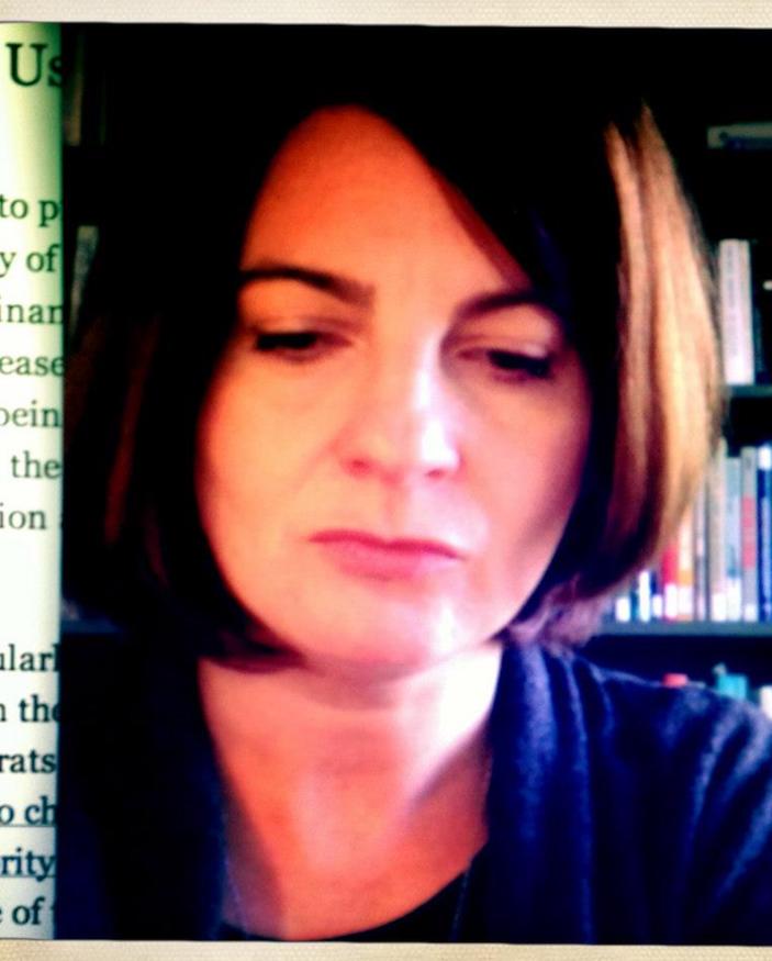 Portrait image of Guillermina De Ferrari in front of book shelves with text at left side of image
