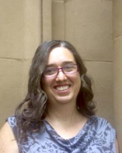 Portrait image of Michelle Stephens wearing a blue shirt in front of a tan wall.