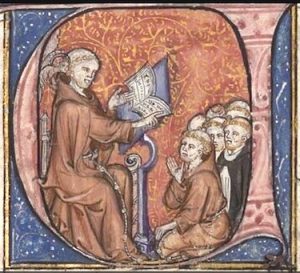 Image of an illuminated initial from a medieval manuscript representing the medieval thinker, John Duns Scotus, sitting at a lectern and lecturing to a group of friars squatting in front of him. A little angel is whispering in Duns Scotus's right ear.