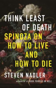 A book image of "Think Least of Death Spinoza on How to Live and Die" There is a colorful still life painting of flowers behind the words.