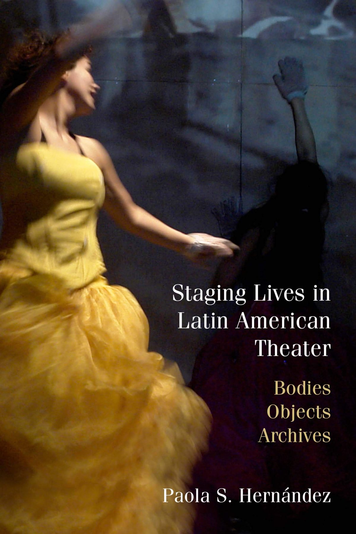 The image is over the cover of the book of Staging Lives in Latin American Theater. The background is dark gray with the image of a woman in a yellow dress in moment. Perhaps dancing. Her face is turned and is not fully visible to the viewer.