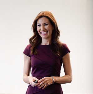 Image Description: This is an image of Julia Domínquez. She is standing in front of a whiteboard and smiling.