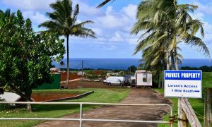 A “private property” sign sits in front of property owned by Facebook CEO Mark Zuckerberg’s home on the island of Kauai; Pacific Ocean in the background.