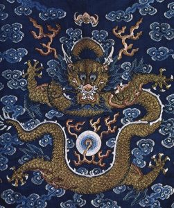 A textile featuring a golden Chinese dragon on a navy-blue field. The dragon is surrounded by auspicious clouds and is looking at a flaming pearl.