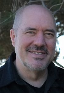 Image description: this is a headshot of Steven Hutchinson. He is looking directly at the camera and smiling. He is wearing a black shirt.