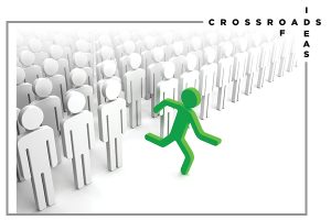 This is an image of many white stick figures all looking identical and standing in rows, but one green stick figure is running forward out of the image and away from the group. 