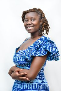 This is a headshot of Jacqueline-Bethel Tchouta Mougoué, turned to the tight side and smiling at the camera.