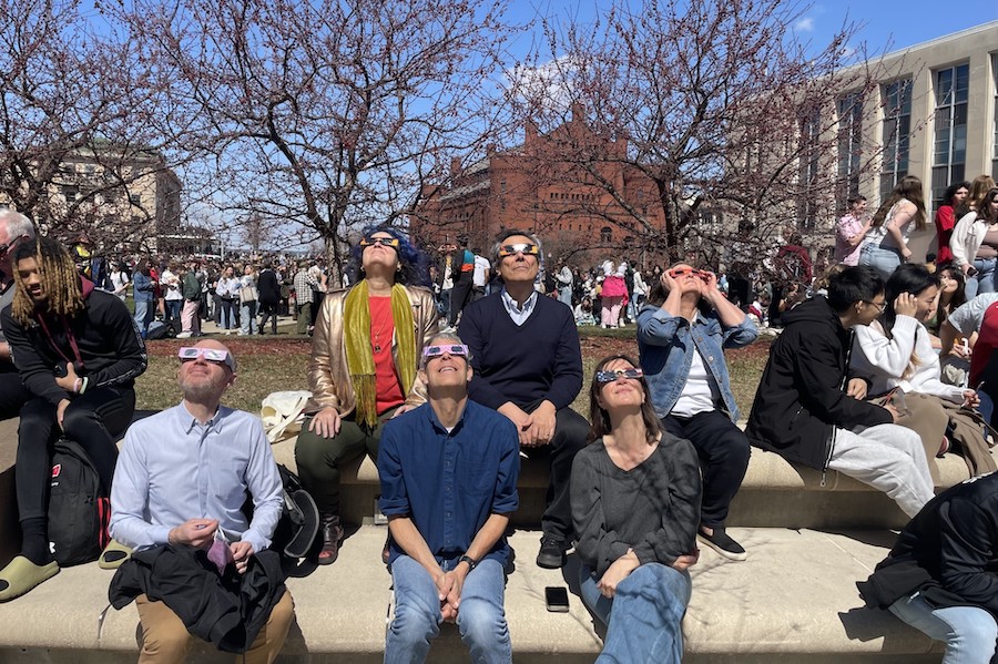 IRH fellows on library mall looking up at the eclipse. 