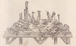 A beige and black drawing of surgical instruments on a wooden table.