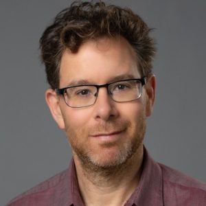 This is a photograph of a man wearing glasses. From the neck up.