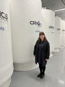 Allyson Gross stands in front of a cryonics chamber. 