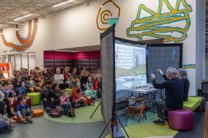 An audience watches a performance of a shadow puppet play.